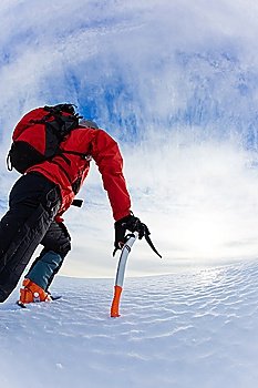 Mountaineer climbing a glacier; vertical frame.