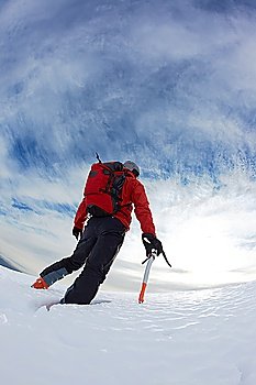 Mountaineer reaching the top of a snowy mountain. Vertical frame.