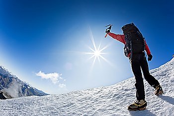 Mountaineer reaching the top of a snowcapped mountain peak,  Mt. Grivola, west italian alps, Europe. Horizontal frame.