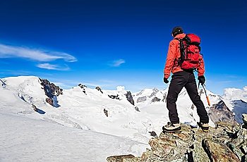 Male hiker standing in front of Monte Rosa Glacier during an high altitude hiking. Switzerland, Europe.