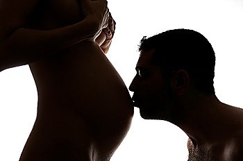 A man kissing a pregnant women´s belly
