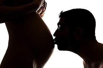 A man kissing a pregnant women´s belly