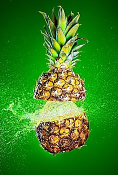 Pineapple splashed with water on a green background