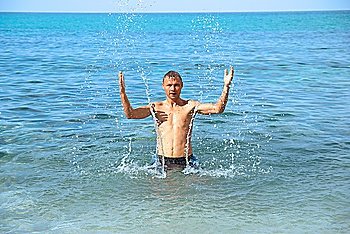 Happy man in the tropical sea with splashes 