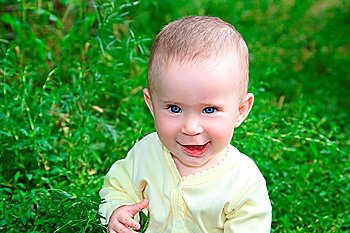 happy smiling baby sitting in grass