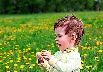 baby girl picking dandelion flowers on meadow