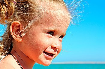 smiling happy little girl on beach near sea