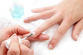 womans finger nails having clear varnish applied on white towel