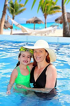 mother and daughter hug in pool tropical beach Caribbean background
