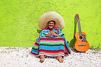 Mexican typical lazy topic man guitar poncho sit in green wall