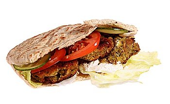A traditional falafel sandwich with the chickpea and herb balls, salad and yoghurt, isolated on white.