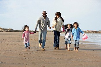 Family Running On Winter Beach