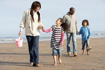 Family Walking By Sea On Winter Beach