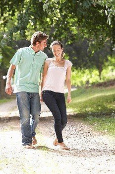 Affectionate Couple Walking In Countryside Together