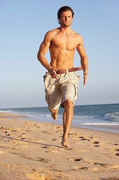 Young Man Running Along Summer Beach