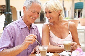 Senior Couple Enjoying Coffee And Cake In CafZ