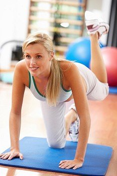Young Woman Doing Stretching Exercises In Gym