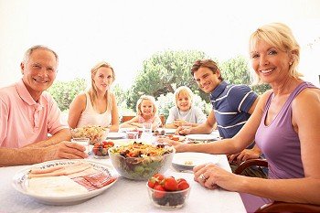 Extended family, parents, grandparents and children, eating outdoors