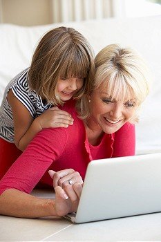 Middle age woman with young girl using laptop computer