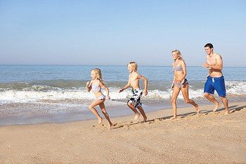 Young family running on beach