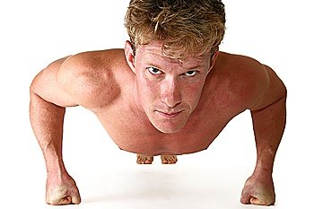 Attractive thirty something man doing push ups over white.