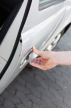 A hand opening the car door