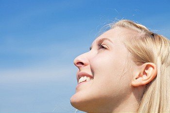 Young woman is looking into sky on a warm day in spring