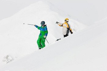 Skier and snowboarder in the snow in an alpine winter landscape in anticipation of the next downhill race