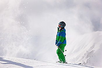 Skier dusting some snow in the alps in anticipation of his next downhill race