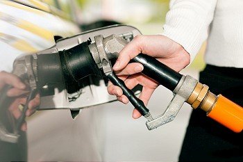 Woman - just hand to be seen - refueling her car with LPG gas at a station