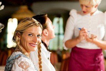 Couple in Bavarian Restaurant ordering food and drinks from the waitress
