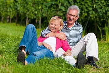 Visibly happy mature or senior couple outdoors arm in arm 