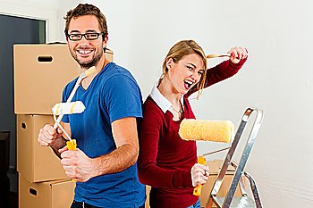 Young couple moving in a home or apartment, they are painting and doing renovation work 