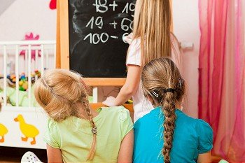 Children – sisters - playing school in their room
