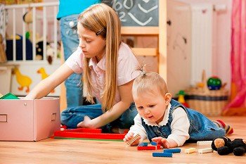 Children – sisters - playing at home; one child is still a baby