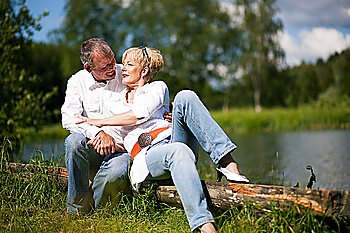 Mature or senior couple being very close to each other at a lake