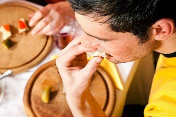 Young man eating a traditional dinner with pickles and bread