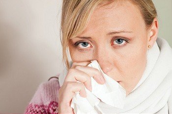 Woman sneezing, having a flu and looking feverish