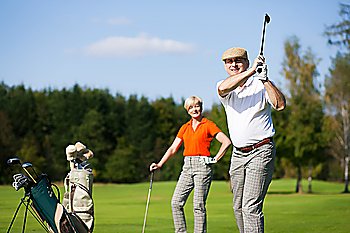 Mature or senior couple playing golf in summer