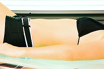 Woman getting a tan in the solarium on a sunbed machine