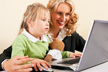 Family Business - telecommuter Businesswoman and mother showing her little daughter how these computer and internet things work