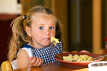 Young girl eating pasta