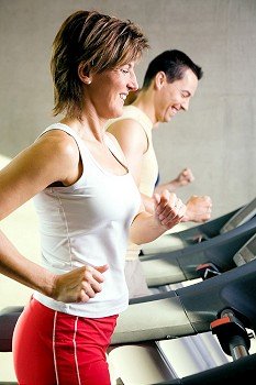 People exercising by  running on the treadmill in a gym