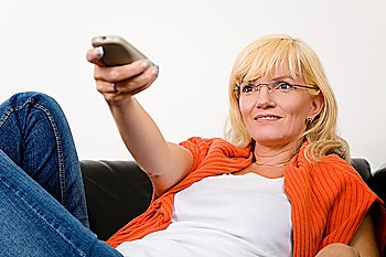Woman on a sofa with a tv remote control (focus on face)