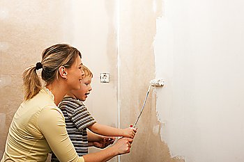 Family - mother with son - painting the wall of their new home or apartment, apparently they just moved in