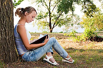 young woman reading book in the park