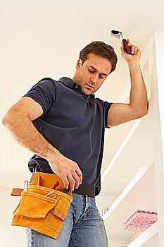 Electrician Installing Light Fitting In Home