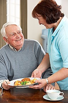 Senior Man Being Served Meal By Carer