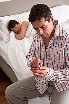 Suspicious Husband Checking Wife´s Mobile Phone Whilst She Sleeps
