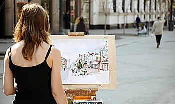 young woman painting outside, focus point on image